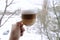On snowy background, transparent mug of aromatic cappuccino, amnricano, latte
