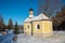 Snowy bavarian winter landscape with traditional church, blue sky