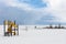 Snowy beach near a frozen sea with a playground for children