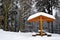 Snowy bench in winter landscape.