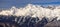 Snowy Chugush mountain peak and blue sky with clouds scenic winter landscape. Main Caucasus ridge panorama