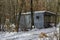 Snowy cosy nook with wooden shelter for winter relaxation with friend in the deciduous forest