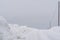 Snowy Countryside Road with Snow Piles and Power Lines Aside