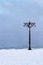 Snowy embankment along the misty river with lantern at the foggy morning - winter landscape. III