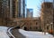 Snowy footpath bending away from the riverwalk in downtown Chicago Loop