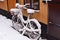 Snowy forgotten old bike on a winter street of an old European city