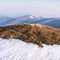 Snowy hills with orange grass