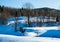 Snowy hills scattered with trees surrounded by forest