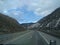 Snowy hills through the windshield of semi truck- with sun shining