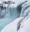 Snowy ice formations created by frozen waterfall at Hranabjargafoss