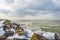 Snowy iced rocks of a dike along a white frozen lake in wetland under a blue cloudy sky in winter