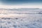 Snowy meadow and grass with hoarfrost by rising cold sun. Beautiful winter landscape. Hazy winter morning