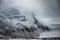 Snowy mountain with eroded surface on gloomy