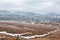 Snowy mountain glade with houses in the distance