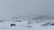 Snowy mountain hills and plains in white clouds and dense fog.