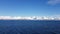 Snowy mountain islands on a blue spring day in the arctic circle as seen from a big ship sailing to Finnmark