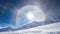 The snowy mountain peak is adorned by a full circle rainbow and solar halo in a majestic, crystal clear sky