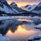 Snowy mountains, blue sea with frosty coast, reflection in water and purple sky at colorful sunset in Lofoten islands,