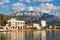 Snowy mountains and green seaside town. Montenegro, winter. View of embankment of Tivat city