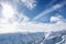 Snowy mountains tops with bright blue sky and clouds