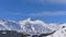 Snowy panorama of high mountains, with green pines