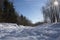 A snowy path in a Landscape in winter with a lot of snow, bright sun and blue sky in the high Rhoen, Germany