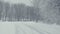 Snowy path with trails. Winter landscape, falling snow, covered with fresh powder.