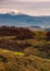 Snowy peak behind the rolling hills in autumn