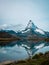 The snowy peak of the Matterhorn in Switzerland is reflected in the surface of a mountain lake