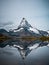 The snowy peak of the Matterhorn in Switzerland is reflected in the surface of a mountain lake