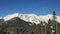 Snowy peaks of the Caucasus mountains, pine forest, blue sky