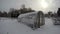 Snowy plastic greenhouse in farm in winter, time lapse 4K