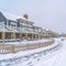 Snowy road with footprints along lovely homes