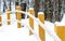 Snowy road forest walk yellow wooden pillars bent curtain railings