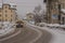 Snowy road in the village of Vodo di Cadore in Italy during heavy snow. One van is driving on a snow covered street