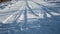 Snowy road wheel marks sunny winter day close up. Snow-covered rural roadway.