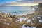 Snowy and rocky overlook of the ocean and beach during winter