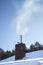 Snowy roof of the chimney from which smoke inside. Air pollution from households.