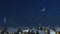 Snowy roofs with smoking chimneys at winter night