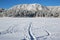A snowy single track trail heads toward Mount Herman on a freezing cold Monument Lake near Monument, Colorado.