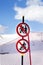 Snowy ski slope, fence and two prohibitory traffic sign on ski resort