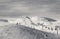 Snowy ski track prepared by snowcat, chair-lift, skiers and snowboarders in ski resort