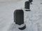 Snowy squares and streets with mosaic cobblestone tiles made of granite and white marble separated by stone bollards stone pillars