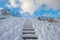 Snowy stairway on a frozen hill in sunlight