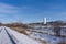 Snowy straight railroad track - industrial business with equipment off the tracks -  near the Minnesota River and near coal power