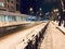 Snowy street with road and buildings at night in Ukraine. Kharkiv winter streets. Travel and tourism in Ukraine concept