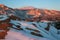 A snowy sunrise in the Garden of the Gods with Pikes Peak mountain in the background.