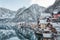 Snowy village Hallstatt by lake at foot of snow mountain with clear sky in winter in Austria