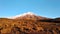 Snowy volcano sunset with blue sky