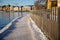 Snowy walking path at Stockholm bay on sunny freezing winter day with wooden Scandinavian fence